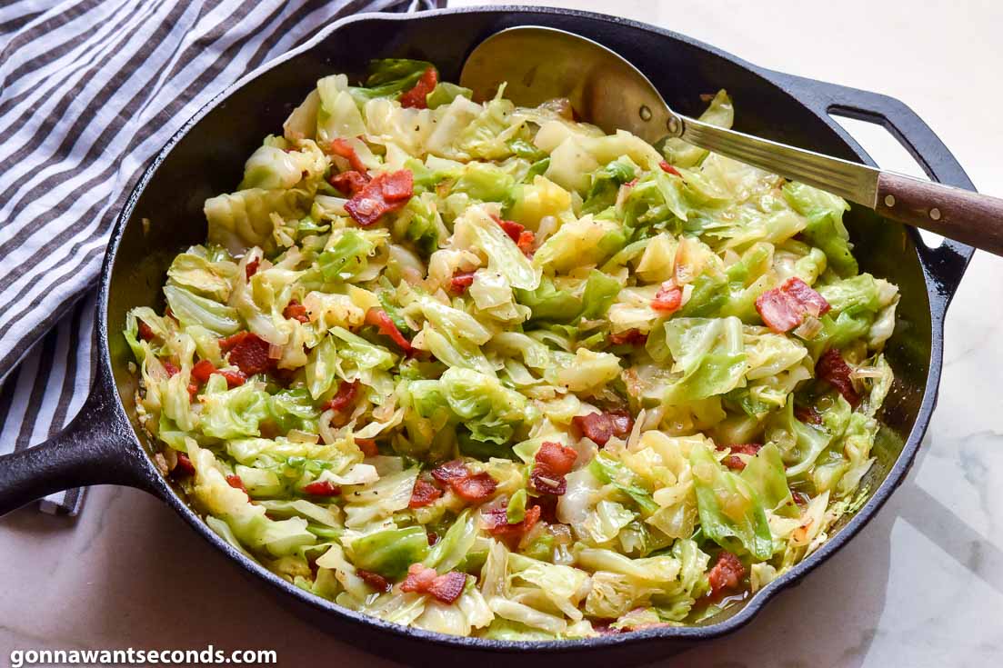 fried cabbage with bacon in a cast iron skillet