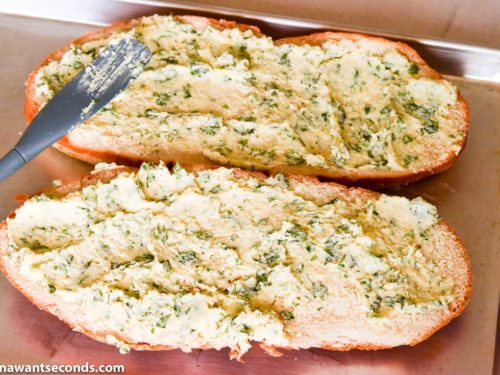 How to make Garlic Bread, spreading the butter on the sliced bread