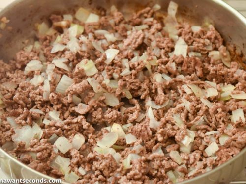 Step 2 how to make ground beef taco casserole, Add onions and continue to cook. Drain excess fat.