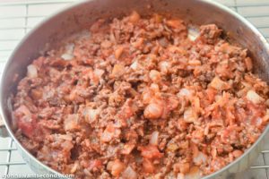 How to make taco casserole, adding taco seasoning and salsa to the beef