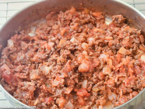 How to make taco casserole, adding taco seasoning and salsa to the beef