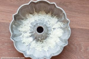 How to make Louisiana Crunch Cake, sprinking coconut flakes to the of the bundt pan