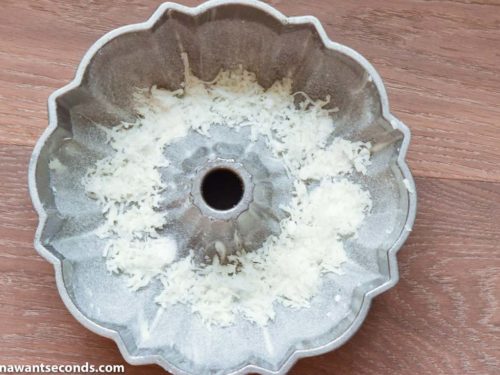 How to make Louisiana Crunch Cake, sprinking coconut flakes to the of the bundt pan