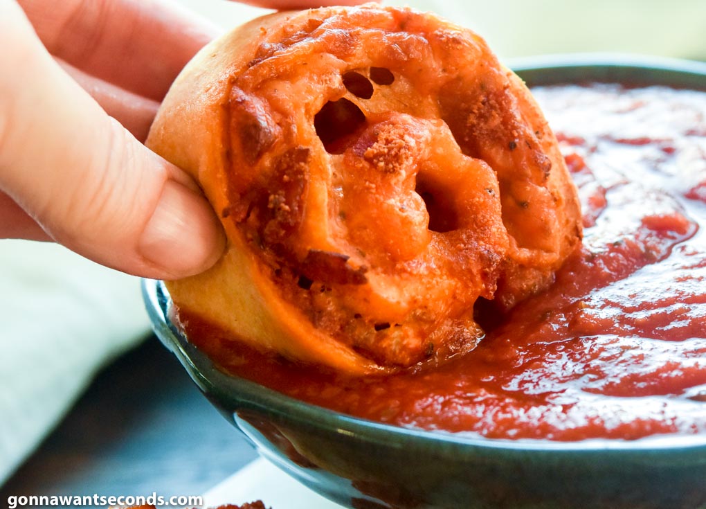 Pizza Pinwheels dipping in pizza sauce