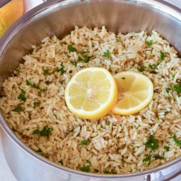 Greek Rice topped with sliced lemons, in a pot