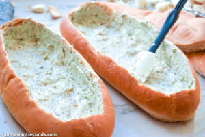 How to make Spaghetti Stuffed Garlic Bread, spreading garlic butter spread in bread