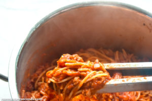 How to make Spaghetti Stuffed Garlic Bread, mixing sauce and spaghetti