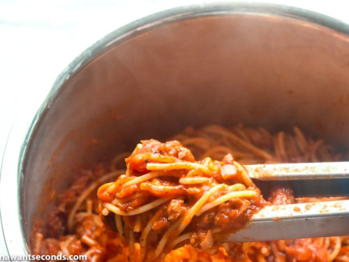 How to make Spaghetti Stuffed Garlic Bread, mixing sauce and spaghetti