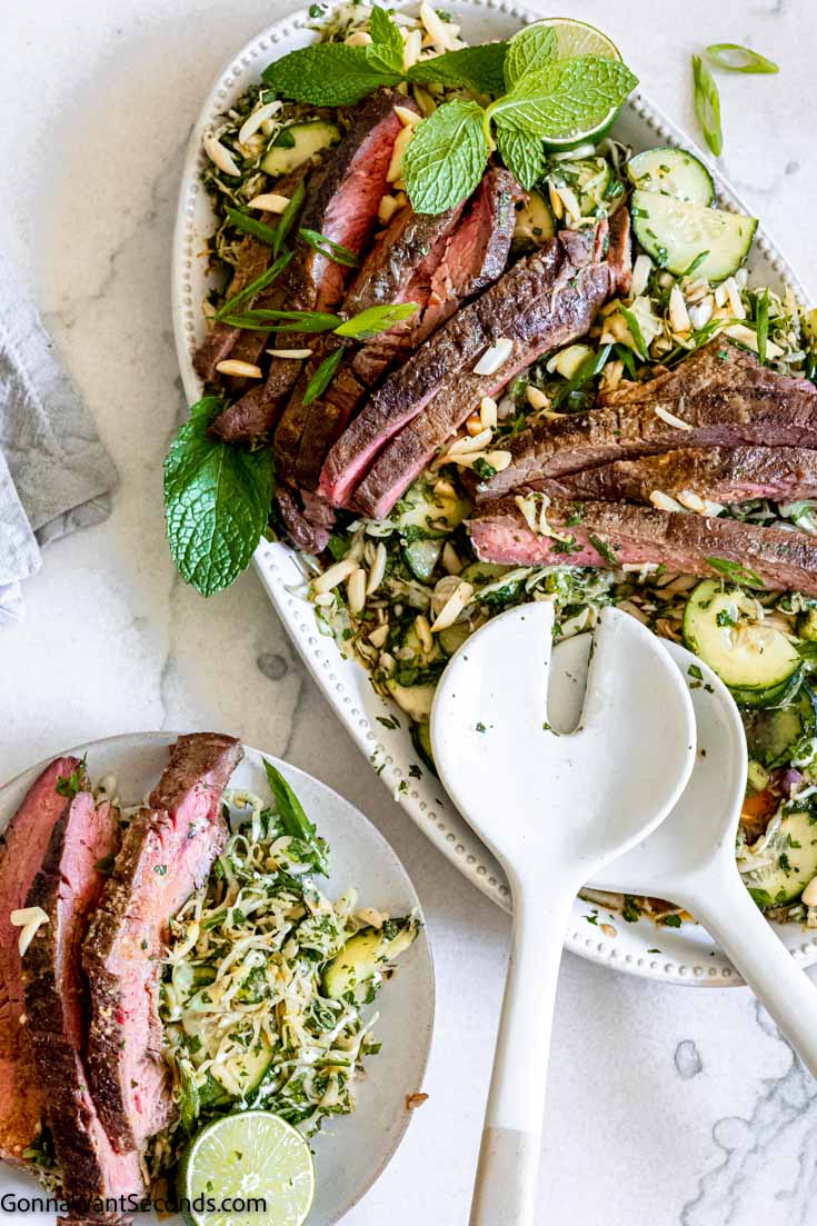 authentic thai beef salad recipe on a serving plate with serving spoon