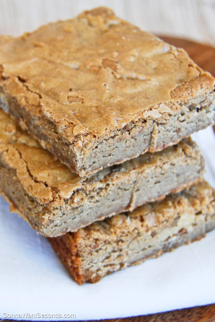 The perfect classic blondies are just that! This blonde brownie is a moist, rich, butterscotchy bar that won't last long around the house. #blondies slices of blondies stack on top of each other