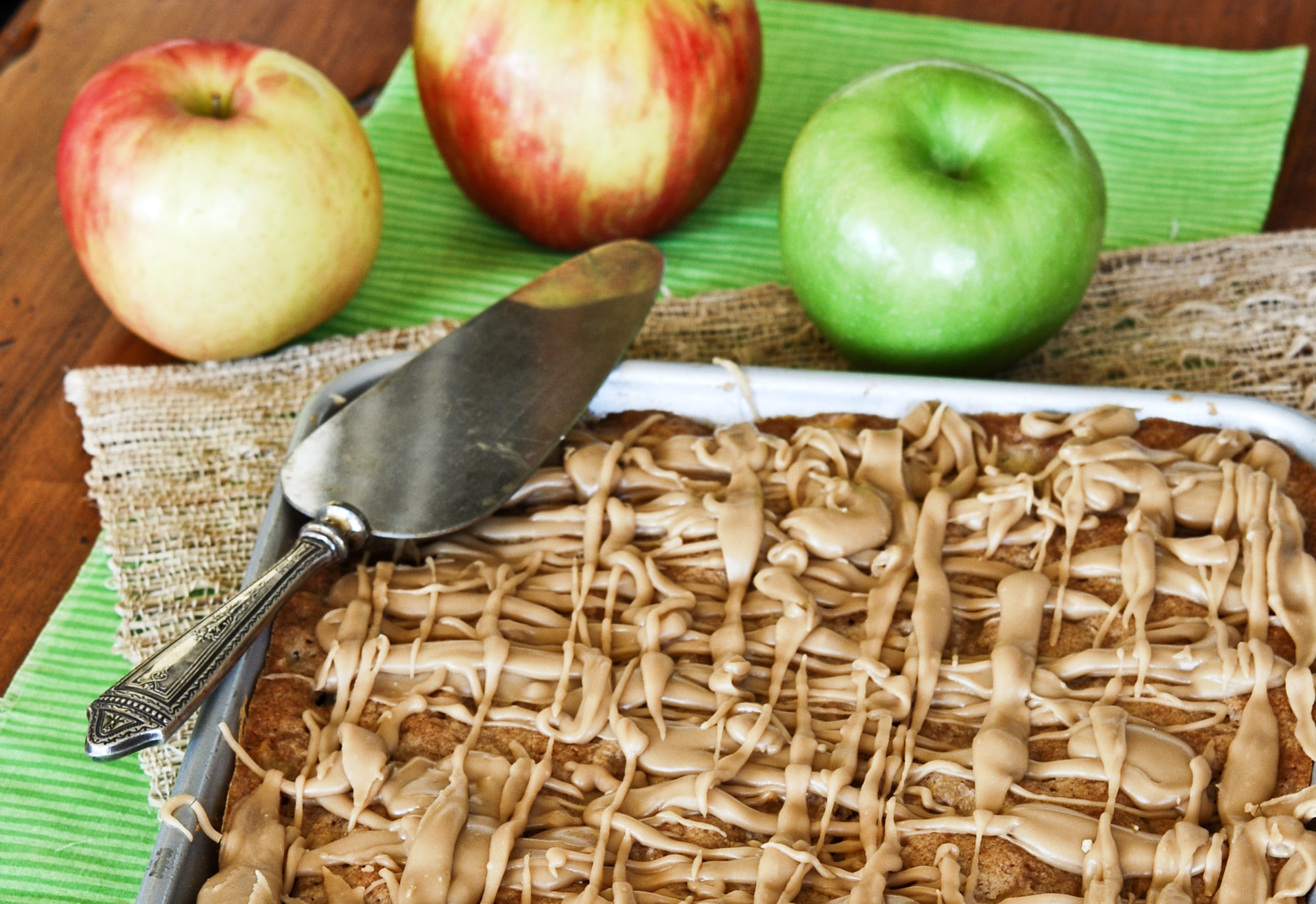 Apple Bars in a baking sheet with caramel glaze on top