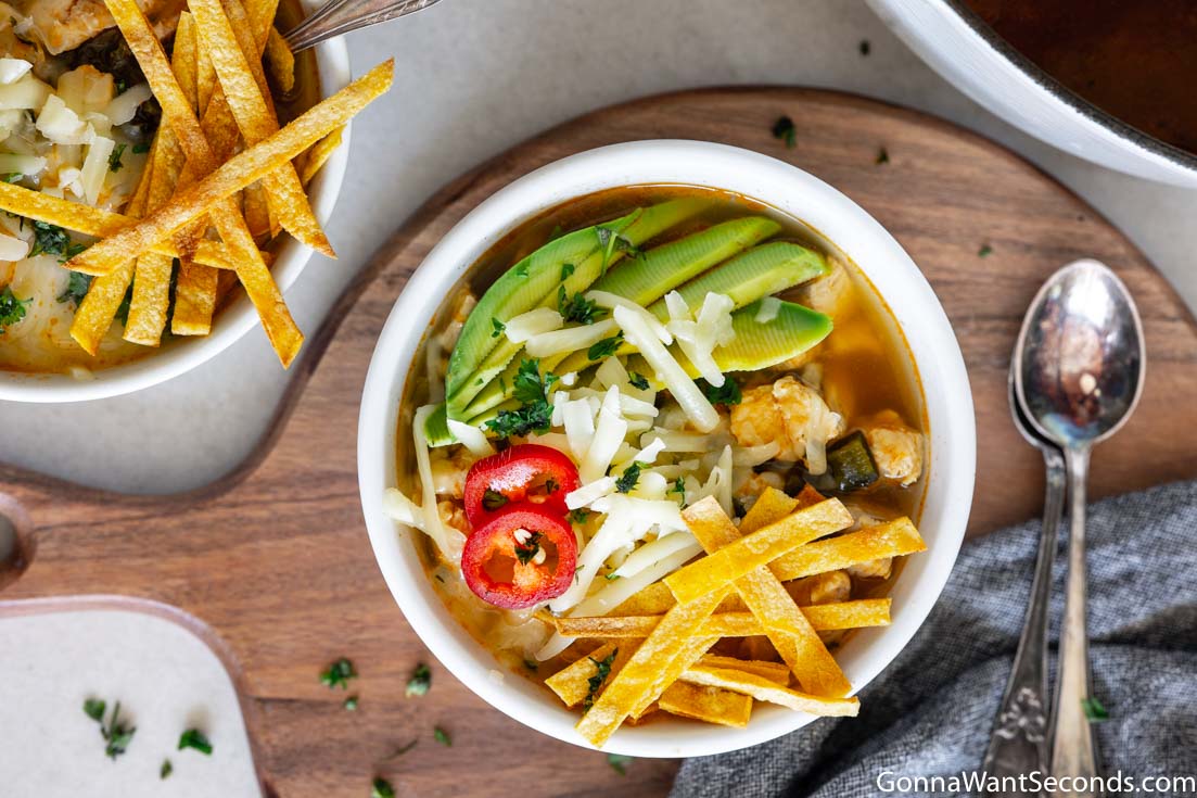 bowls of tortilla soup with chicken, avocado and tortilla strips