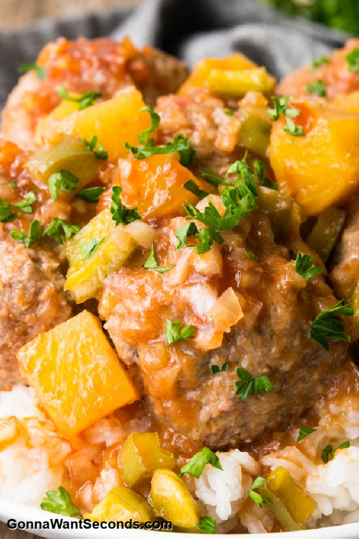 sweet and sour meatballs with pineapple bits on top of rice