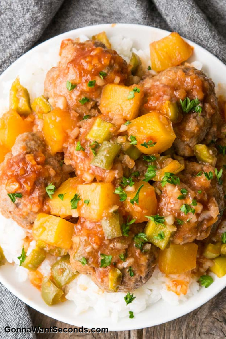 sweet sour meatballs with pineapple bits on top of rice