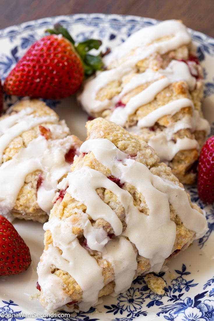 strawberry scones drizzled with glaze, on a plate