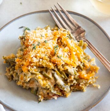 A serving of simple green bean casserole on a plate with fork