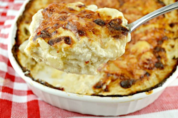 Scooping Potatoes Au Gratin from a casserole dish