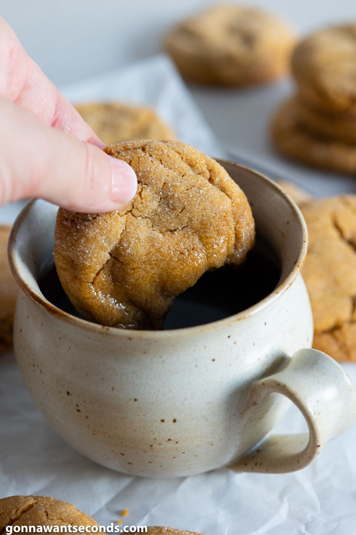 dipping double ginger cookies with butter on a cup of coffee
