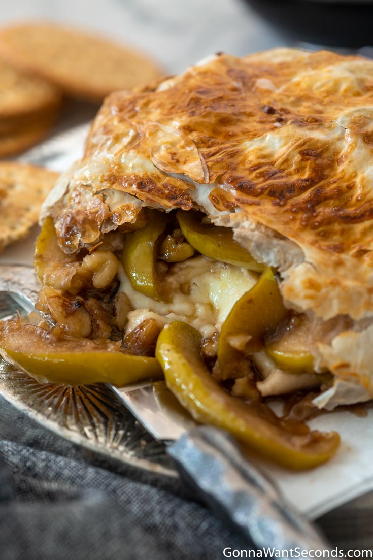 baked brie en croute, showing apples and walnuts inside