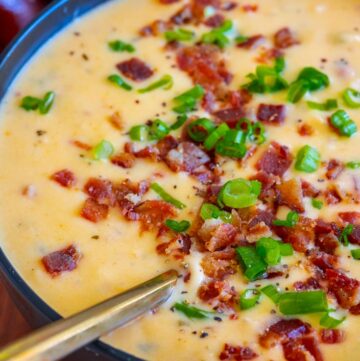 beer cheese soup recipe topped with bacon and green onions in a bowl