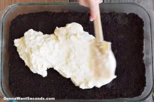 how to make oreo lasagna , spreading the cream cheese mixture on top of the crushed oreo layer