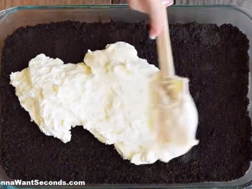how to make oreo lasagna , spreading the cream cheese mixture on top of the crushed oreo layer