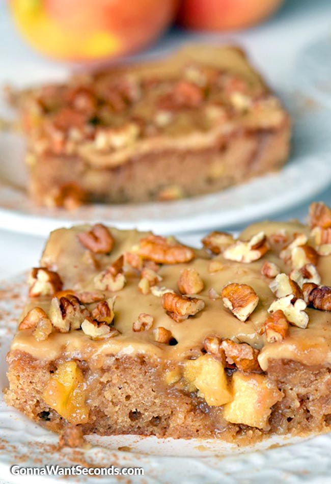 A slice of Caramel Apple Sheet Cake topped with caramel icing and chopped nuts