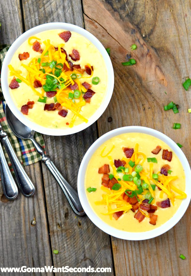 Two Easy Potato Soup topped with bacon bits, shredded cheese, and spring onions, in white bowls