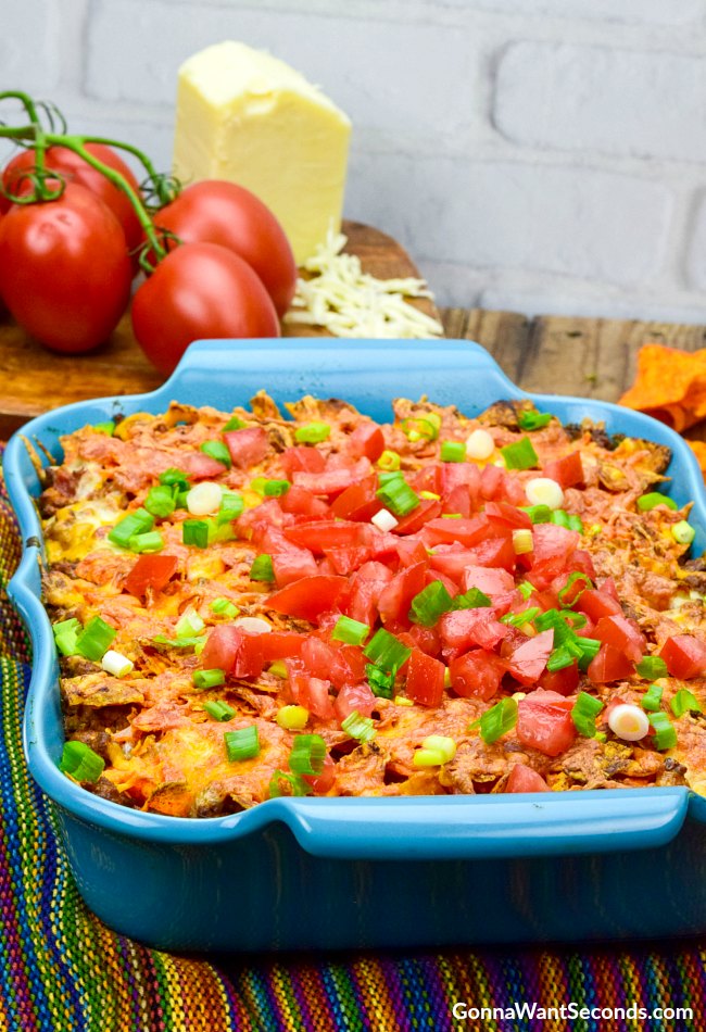 Easy Dorito Casserole topped with fresh tomatoes in a blue casserole dish