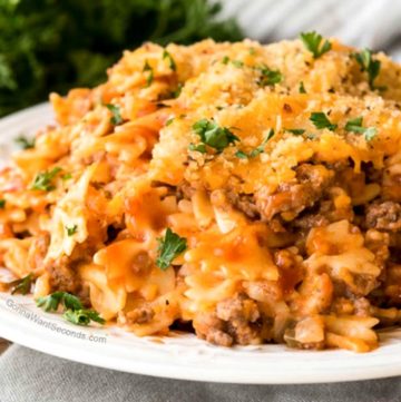 Hamburger Casserole garnished with parsley and bread crumbs on a white plate