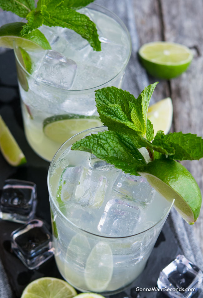  A highball glass filled with Lime Rickey, ice, and lime wedges