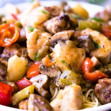 Chicken Murphy topped over angel hair pasta in a white shallow bowl