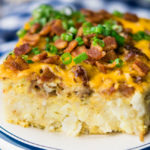 Tater Tot Breakfast Casserole on a plate, topped chopped with green onions and bacon