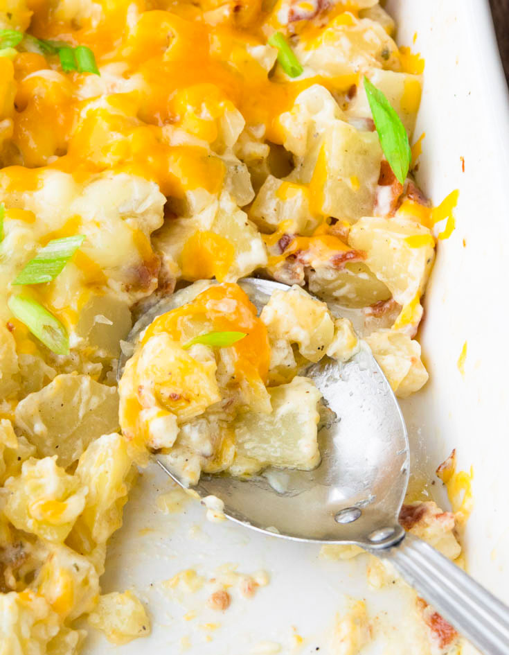 ranch potatoes casserole in a baking dish with serving spoon