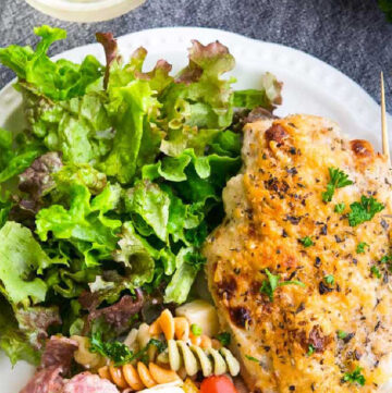Italian Dressing Chicken with pasta salad and greens on a plate