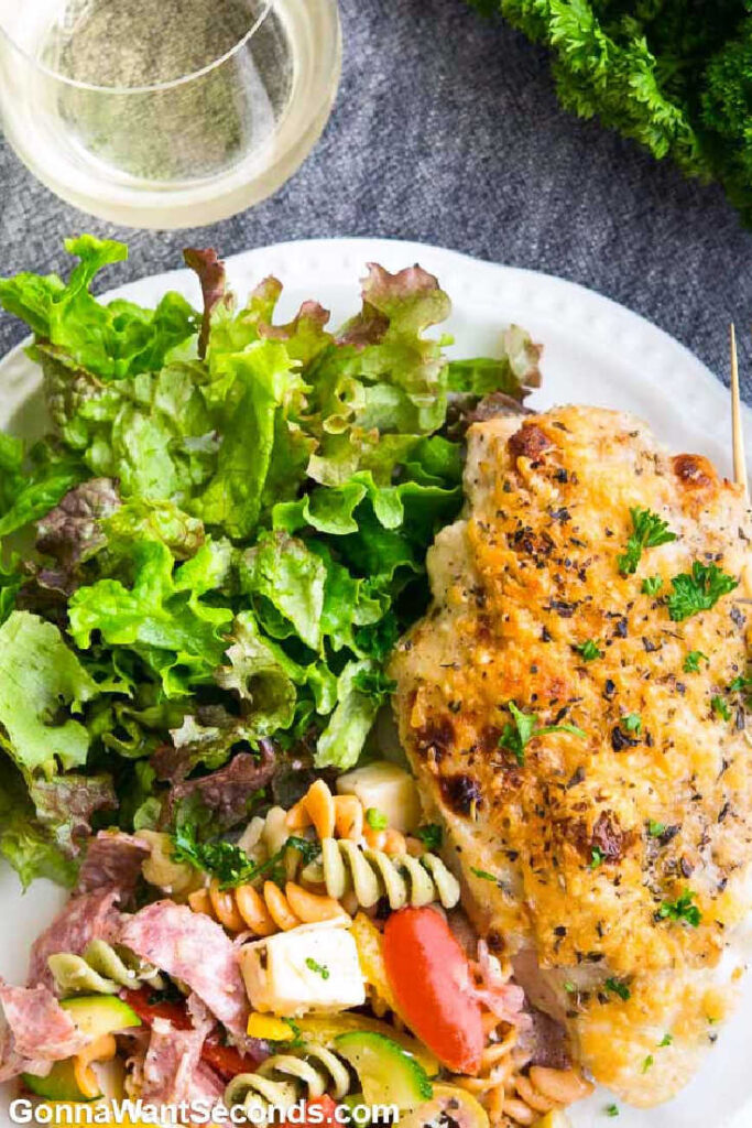Italian Dressing Chicken with pasta salad and greens on a plate