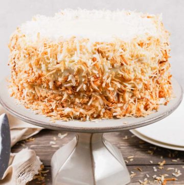 coconut cake with cream cheese frosting on a cake stand