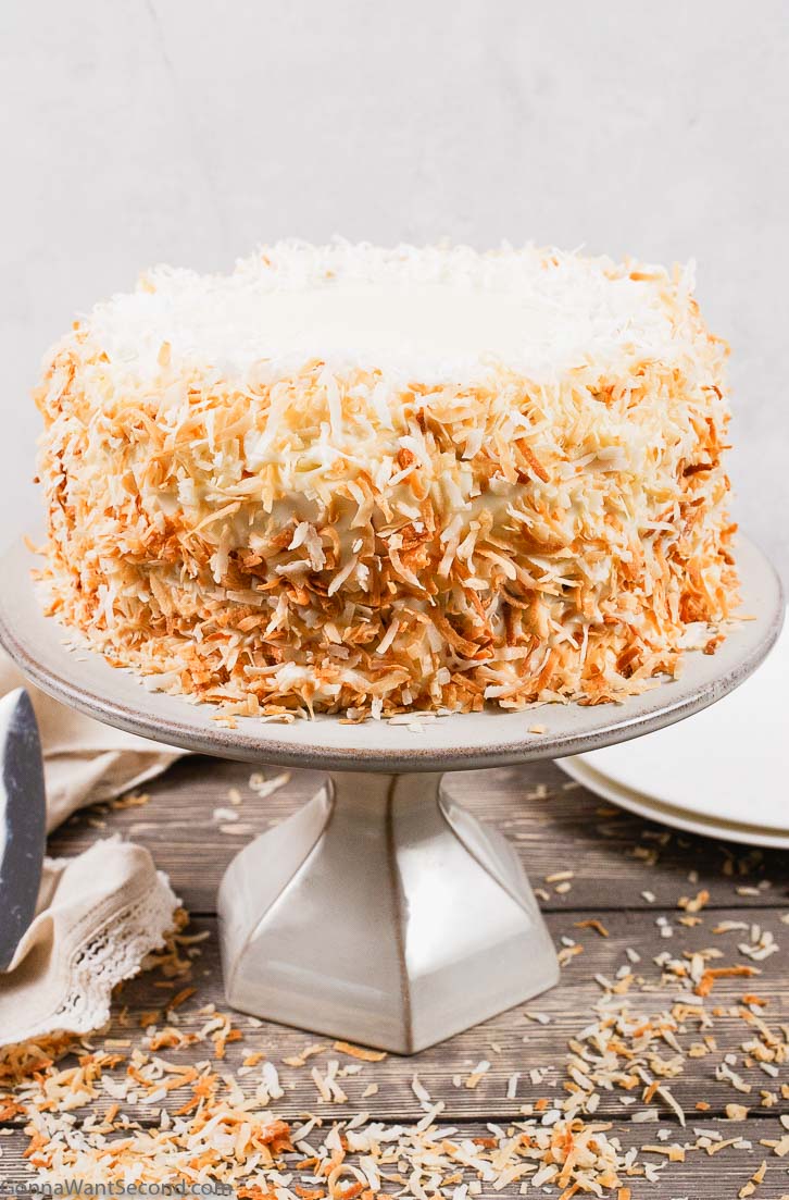 coconut cake with cream cheese frosting on a cake stand
