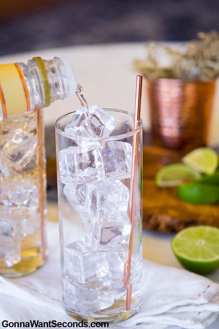 Pouring gin in a glass filled with ice
