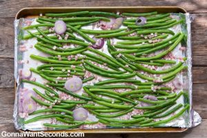 Roasted Green Beans arranged on an aluminum foil covered baking sheet