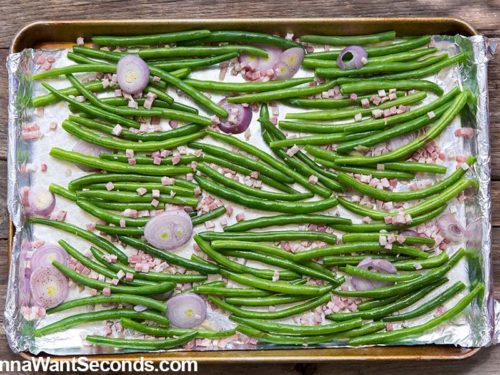 Roasted Green Beans arranged on an aluminum foil covered baking sheet