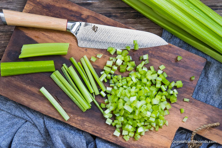 Chopped Celery on a wooden chopping board with knife. Shrimp Pasta Salad
