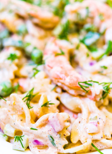 Close up, shrimp pasta salad old bay garnished with fresh dill