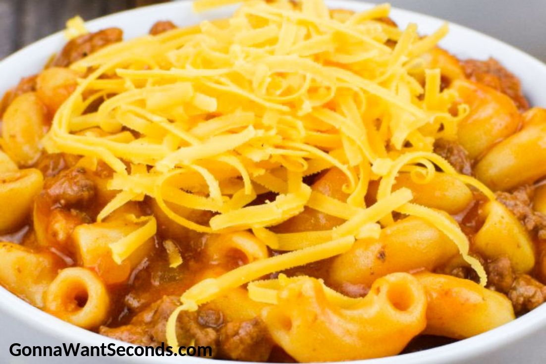 Beefaroni topped with shredded cheese in a bowl