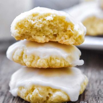 Anise Cookies stack on top of each other, with a glass of milk at the back