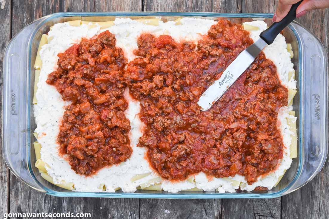 How To Make Baked ziti with ricotta, layering pasta and sauce in a casserole dish