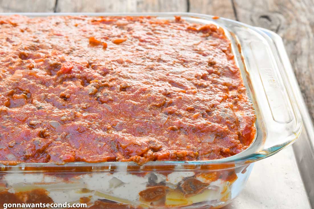 How To Make Baked ziti with ricotta, layering pasta and sauce in a casserole dish