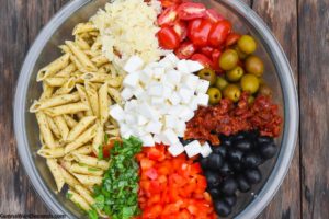 Step 2 how to make Mediterranean pasta salad, Mediterranean pasta salad ingredients in a bowl