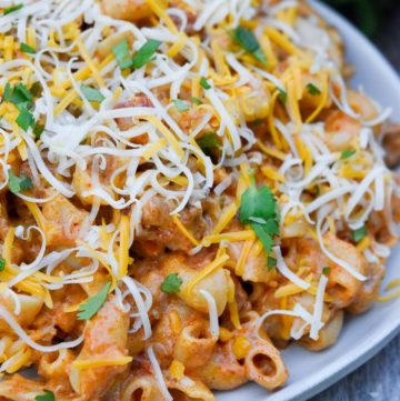taco pasta topped with shredded cheese on a plate