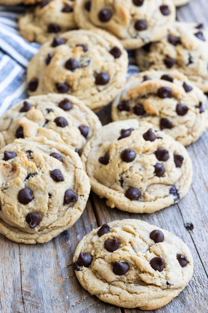 These Best Chocolate Chip Cookies are thick, chewy, buttery, and loaded with melty chocolate for the ultimate bakery-style cookie. #bestchocolatechipcookies #chocolatechipcookies best chocolate chip cookies on a wooden table